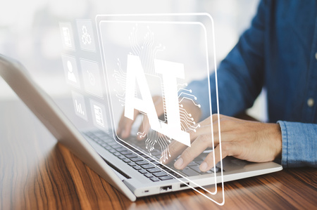 Person skriver på en bärbar dator med en digital AI-symbol på skärmen.