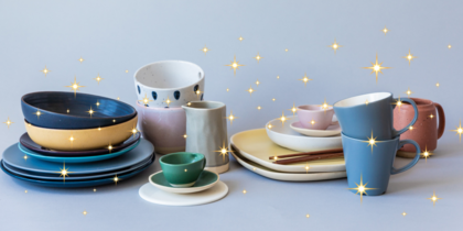 Olika färgglada tallrikar, skålar och koppar står prydligt uppställda med gnistrande stjärneffekter ovanpå.