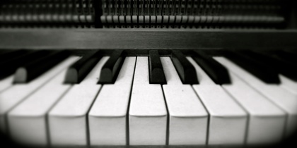 Närbild av pianotangenter i svartvitt, med fokus på de vita och svarta tangenterna.