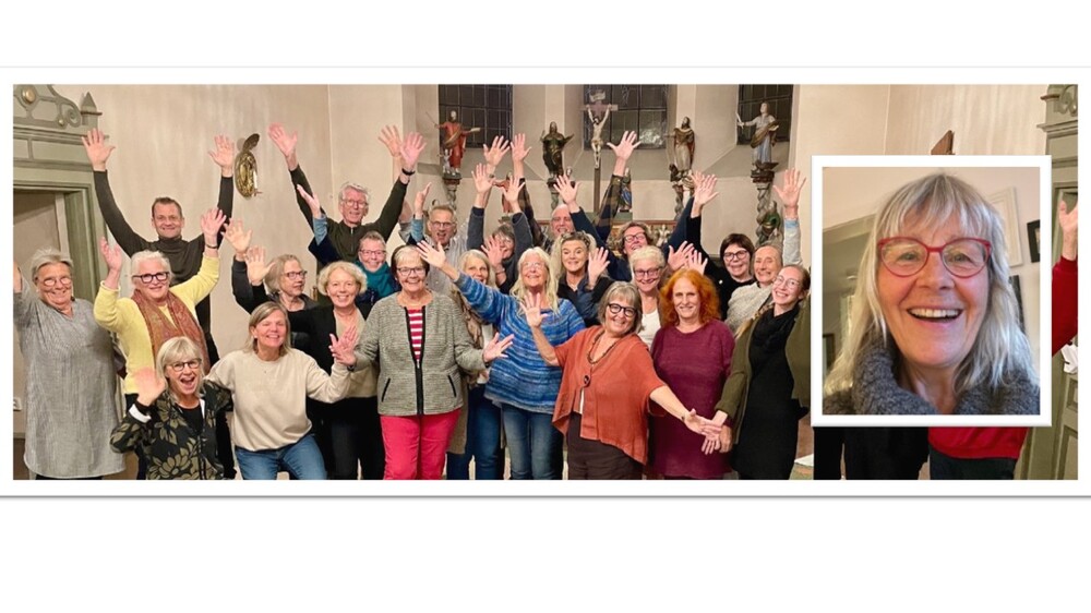 En grupp människor står i ett rum med händerna uppsträckta, glada och sociala.