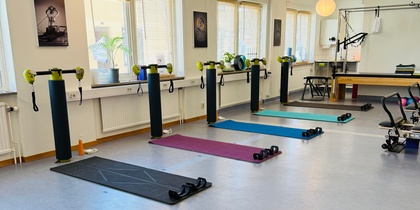 Ljust träningsrum med yogamattor, vikter och träningsutrustning uppställda för gruppträning.