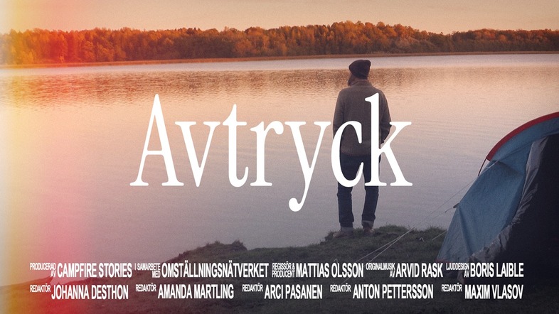 En person står vid en sjö i solnedgången bredvid ett tält. Texten 'Avtryck' syns stort i mitten.