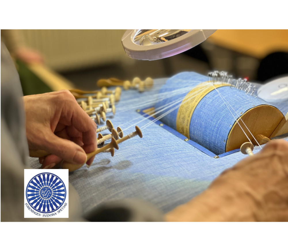 Närbild av händer som arbetar med knyppling på en blå knyppeldyna, med flera trådar och pinnar.