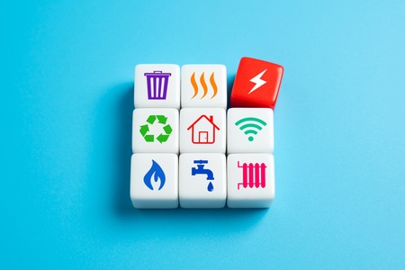 Nio kuber med ikoner för el, vatten, värme, återvinning och andra hushållstjänster på blå bakgrund.