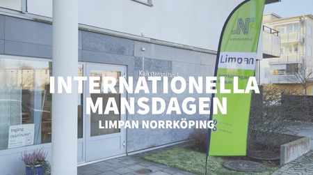 Entré till en byggnad med skylt och flagga för Internationella mansdagen vid Limpan Norrköping.
