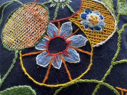 närbild på broderi i olika färger