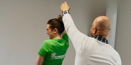 Leende person i SV-tröja dansar med person i vit tröja