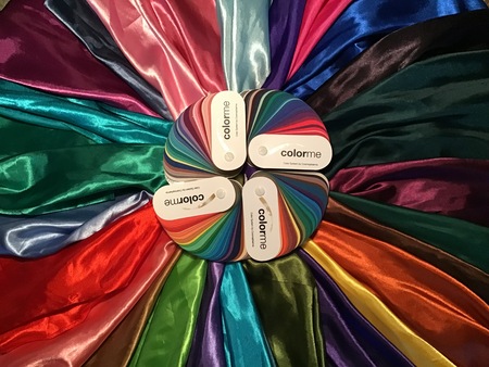 Färgglada tygstycken i cirkel med färgkartor från Color Me i mitten.