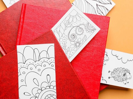 Flera röda anteckningsböcker med svartvita teckningar på papper ovanpå, mot en orange bakgrund.