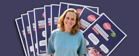 En person i blå tröja står framför flera informationsblad om en studiecirkel för ökat välmående.