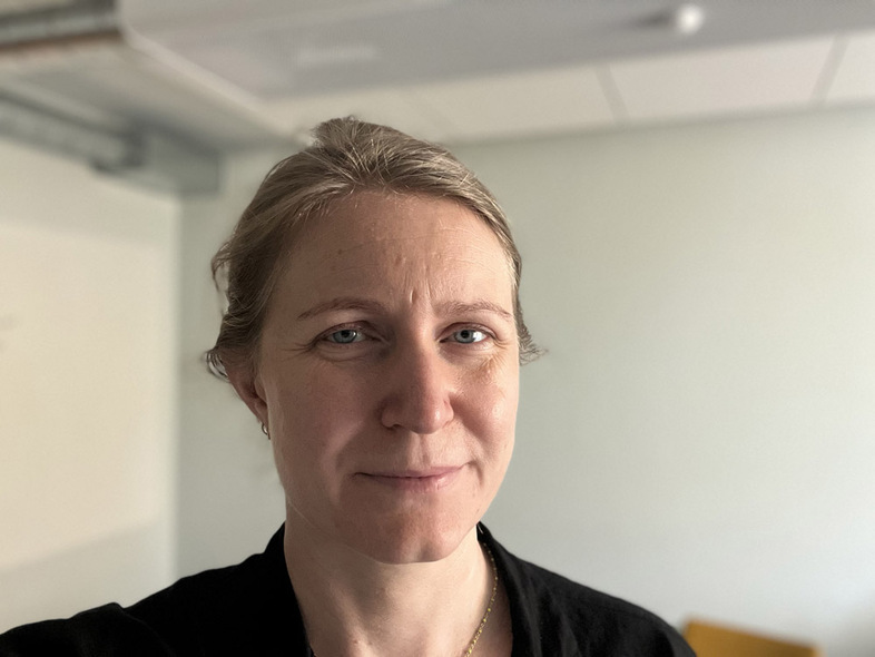 Närbild av en kvinna med blont hår i en ljus inomhusmiljö.