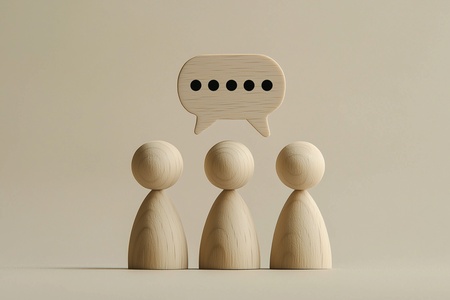 Tre träfigurer står bredvid varandra med en pratbubbla ovanför dem mot beige bakgrund.