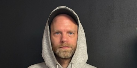 man med keps och luva. grå tröja