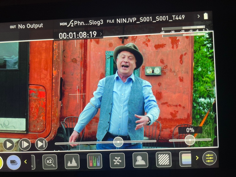 En man står framför en röd sovvagn. 