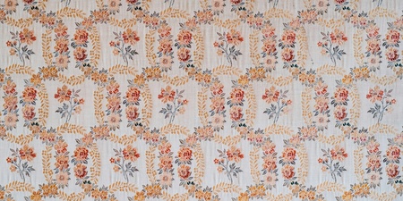 Blommigt mönster på tapet i ljusa färger med inslag av orange, gult och blått.