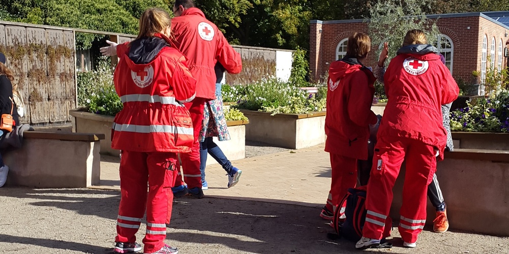 Flera personer i Röda Korset-overaller utomhus