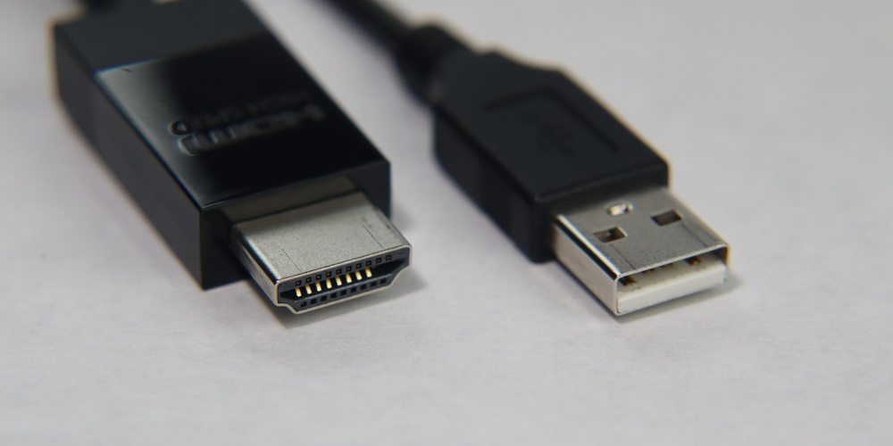 Närbild på en HDMI-kontakt och en USB-kontakt på en vit bakgrund.