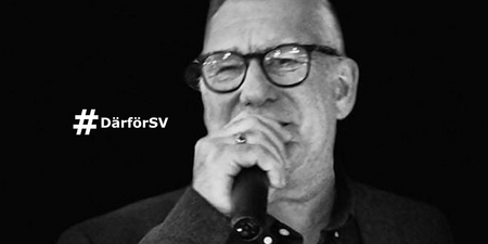 Man med glasögon talar i mikrofon, svartvit bild med texten '#DärförSV' till vänster.