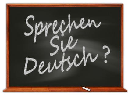 En griffeltavla med texten 'Sprechen Sie Deutsch?' skriven med vit krita.