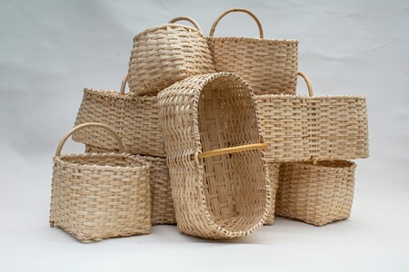 En samling flätade korgar i olika former och storlekar staplade mot en ljus bakgrund.