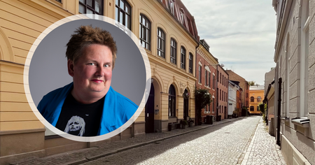 Porträtt av en man i blå jacka infällt över en tom kullerstensgata med färgglada byggnader.