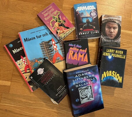 En samling science fiction-böcker ligger utspridda på ett trägolv.