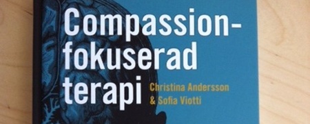 Bokomslag till 'Compassion-fokuserad terapi' av Christina Andersson och Sofia Viotti, med ett öga och två händer på omslaget.