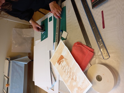 person som skär papper till inramning