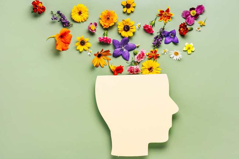En stilistisk illustration av ett ansikte där det kommer ut olika blommor ur skallen.