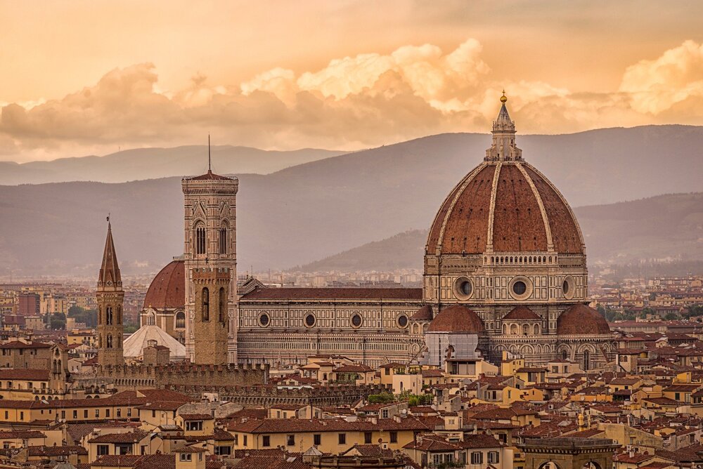 Florens katedral, Duomo di Firenze, med sin stora kupol och stadens tak i förgrunden vid solnedgång.