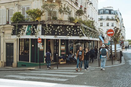 Gatubild av ett parisiskt café med människor som promenerar förbi på trottoaren.