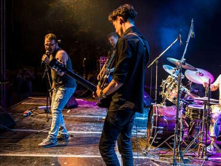 Ett band står på scenen och spelar och sjunger.