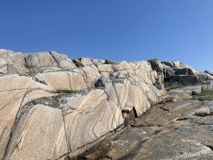 Stora, ljusa klippor med tydliga mönster under en klarblå himmel.
