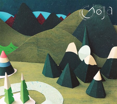 Pappersmodell av ett landskap med berg, granar och en flod i olika gröna och blå nyanser.