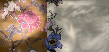 En vägg med blommigt mönstrad tapet till vänster och enfärgad yta med skuggor till höger.