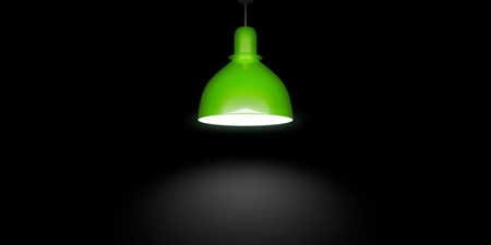 En grön taklampa lyser upp ett mörkt rum med ett koncentrerat ljussken under sig.