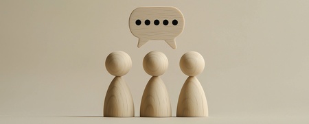 Tre träfigurer står bredvid varandra med en pratbubbla ovanför dem mot beige bakgrund.