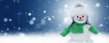 En leende snögubbe med grön halsduk och mössa står i snön mot en blå bakgrund med snöflingor.