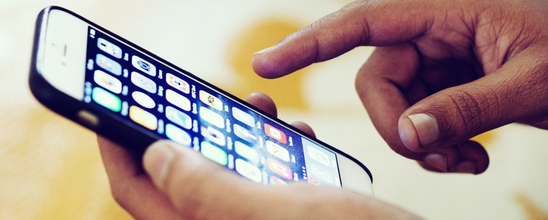 En person använder en smartphone med appar synliga på skärmen.