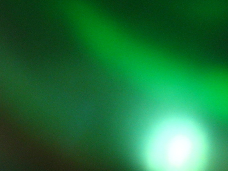 Suddiskt grönt ljus med en ljusare cirkel i nedre högra hörnet.
