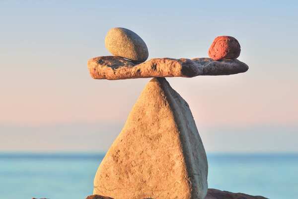 Tre stenar balanserar på en stor spetsig sten.