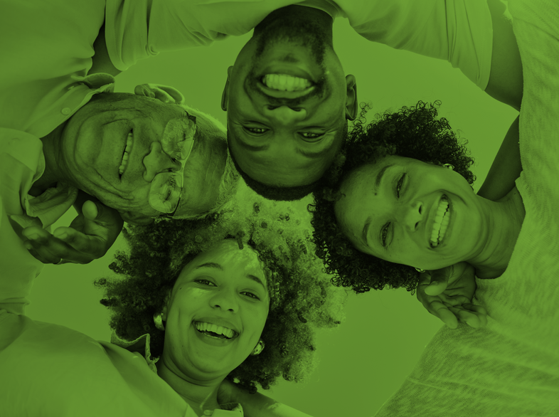 Fyra personer ligger i en cirkel och ler mot kameran, bilden har ett grönt filter.