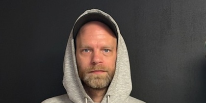 man med keps och luva. grå tröja