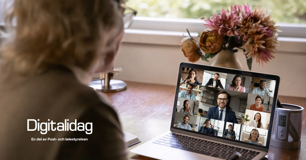 Person deltar i videomöte på laptop vid skrivbord med blommor och fönster i bakgrunden.