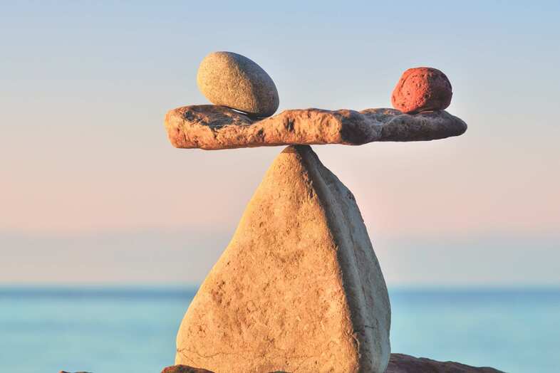 Tre stenar balanserar på en stor spetsig sten.