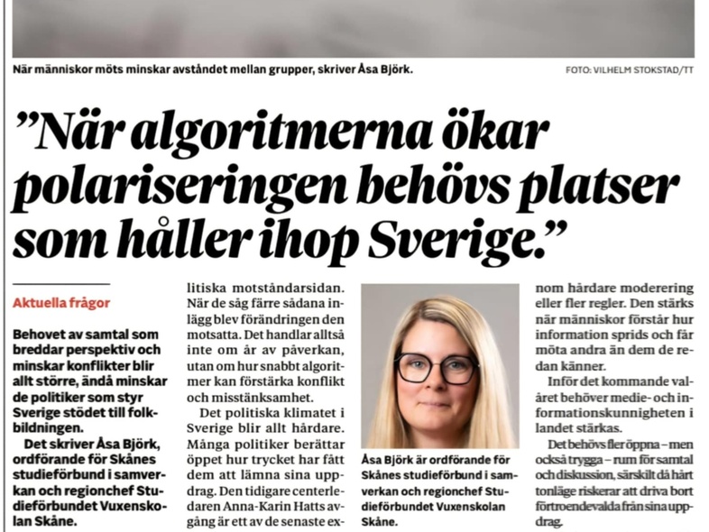 Flera personer skriver tillsammans på ett stort papper vid ett bord, fokus på händer och pennor.