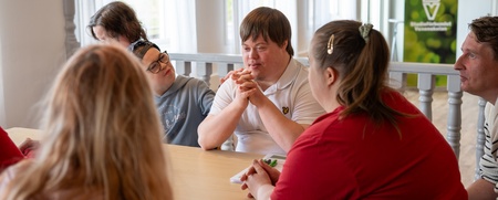 en grupp människor med IF sitter runt ett bord och diskuterar