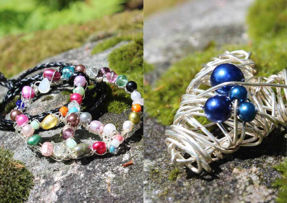 Två smycken ligger på en sten utomhus, ett färgglatt pärlarmband och en silvertrådsring med blå pärlor.