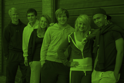 Sex unga personer står i rad utomhus framför en byggnad, alla ler mot kameran.