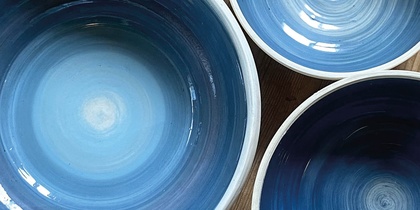 Tre blå keramikskålar på ett trägolv med texten 'Prova på: Keramik' i hörnet.